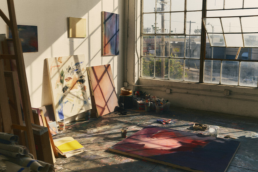 Art studio with paintings on easels and a large window