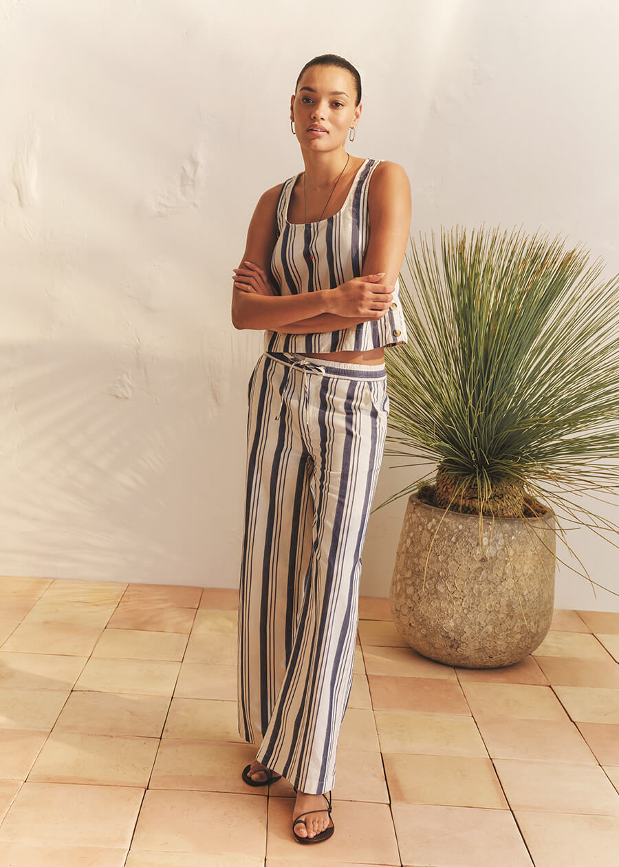 Woman in striped tank and pants standing in room