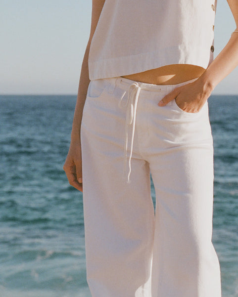 Woman in white shirt and white cinched jeans