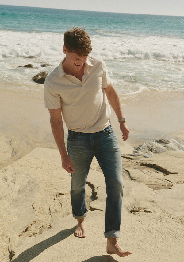 Man walking on a beach with ocean waves in the background
