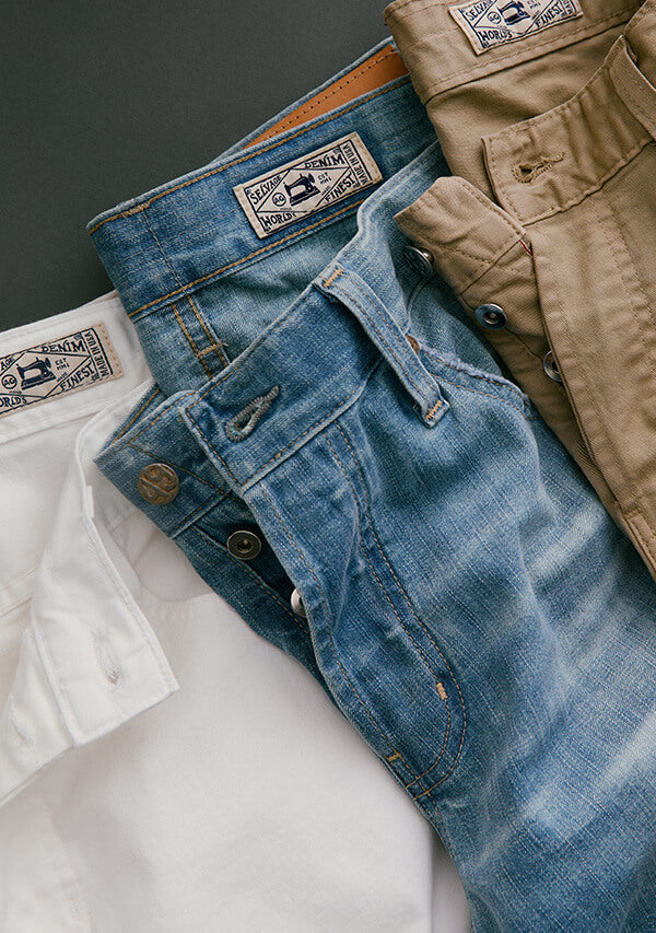 Stack of jeans with AG branding on a neutral background