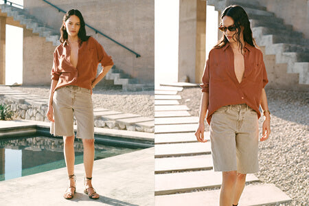Woman in a rust-colored blouse and beige shorts standing by a poolside.