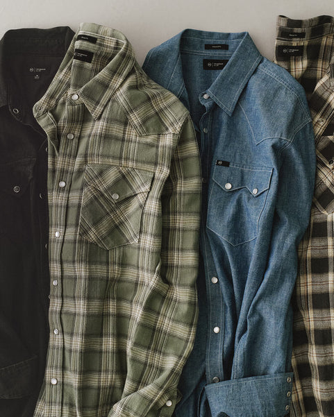 Four shirts in different styles and colors arranged on a white background