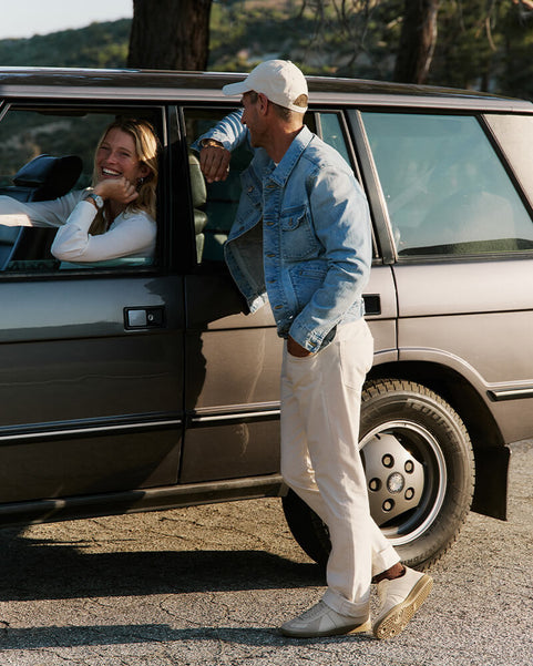 Man and woman by a car on a road trip