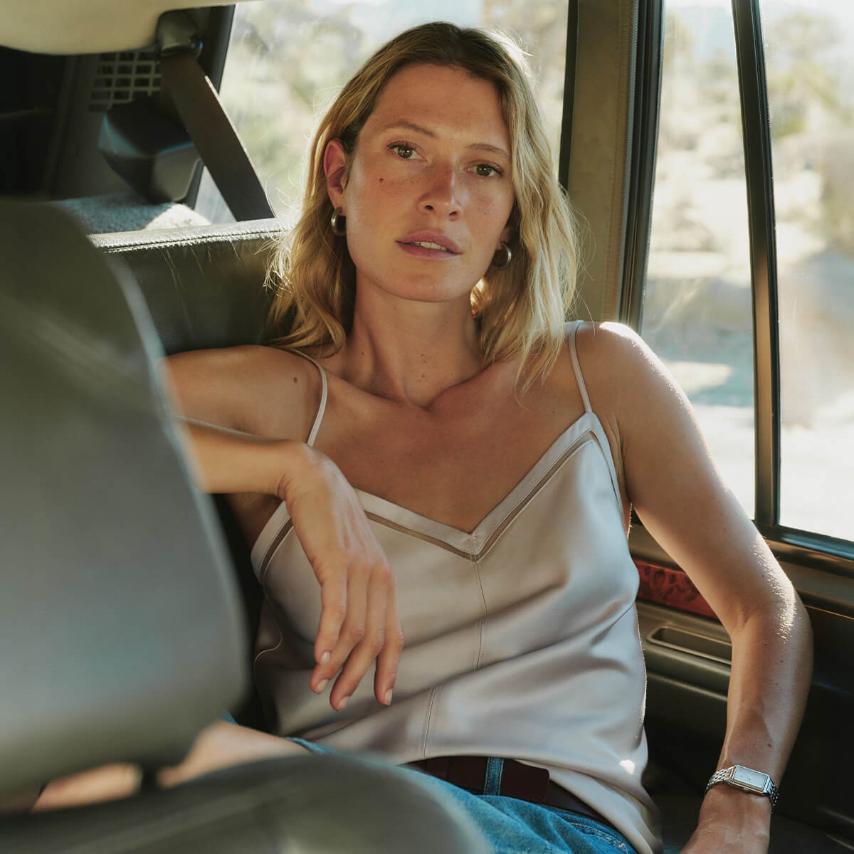Woman sitting inside a vehicle with a blurred outdoor background