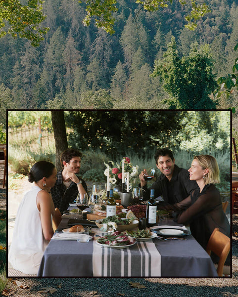 Two couples sitting at a table outdoors with a scenic background