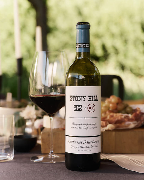 Bottle of Stony Hill Cabernet Sauvignon wine with a glass on a table outdoors.