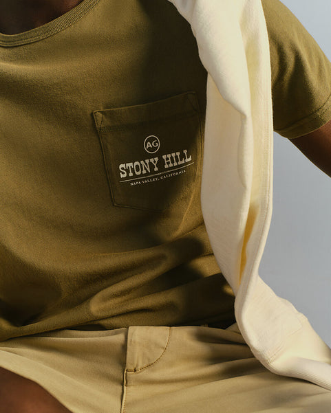 Person wearing a green t-shirt with a 'Stony Hill' logo on a gray background