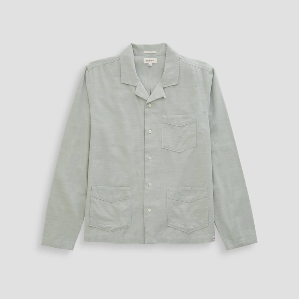 Light gray shirt with collar and two front pockets on a light gray background