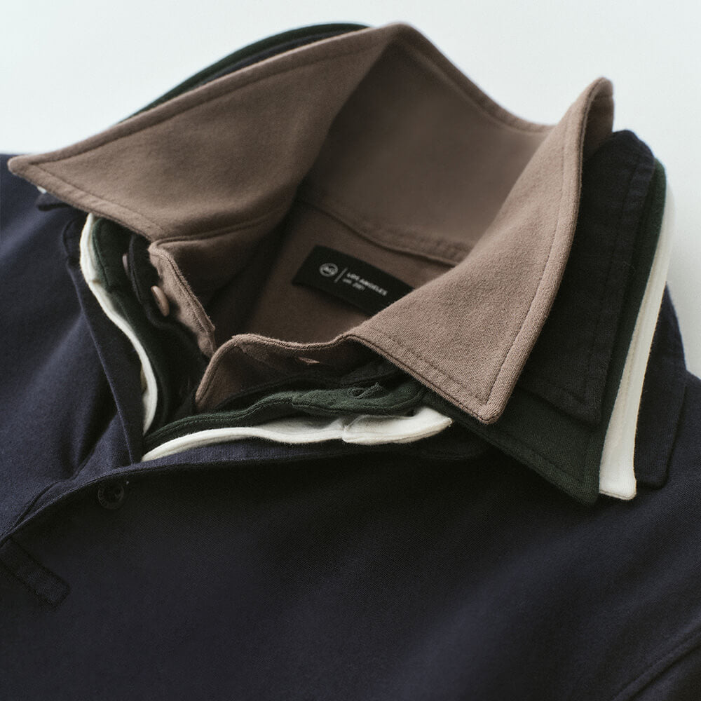 Close-up of polo shirts collars layered in navy, white, green, black, and tan.