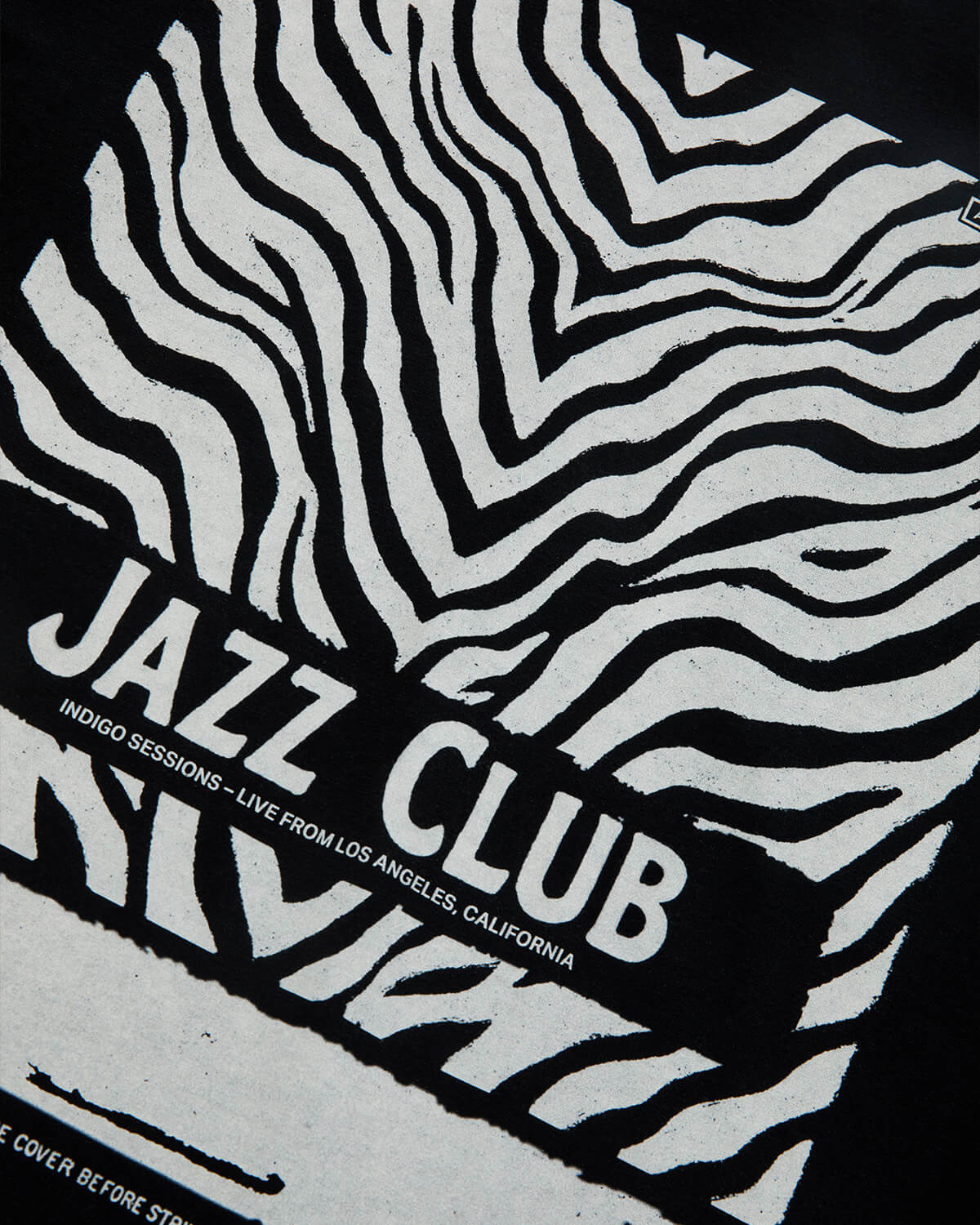 A close-up of a black and white zebra-stripe patterned surface with a bold black banner across the center reading 'JAZZ CLUB' in white text, plus smaller text below.