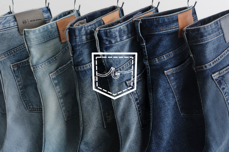 Foundation - Several pairs of blue denim jeans hanging in a row.