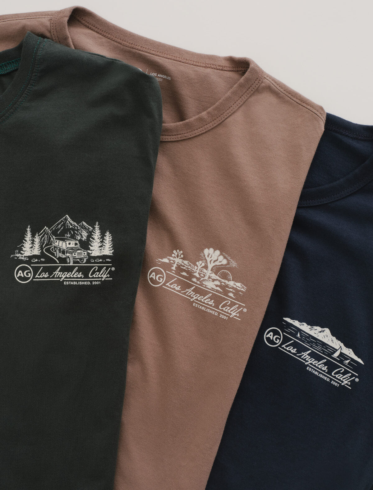 Three shirts in black, brown, and navy with a logo and text on a light gray background