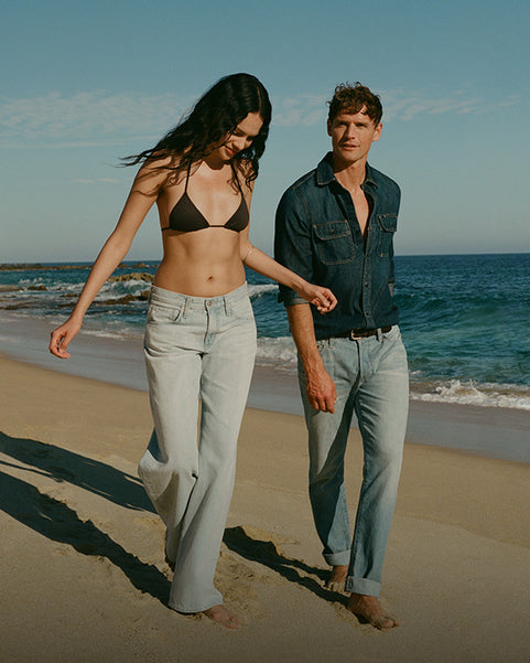 Man and women walking alongside beach
