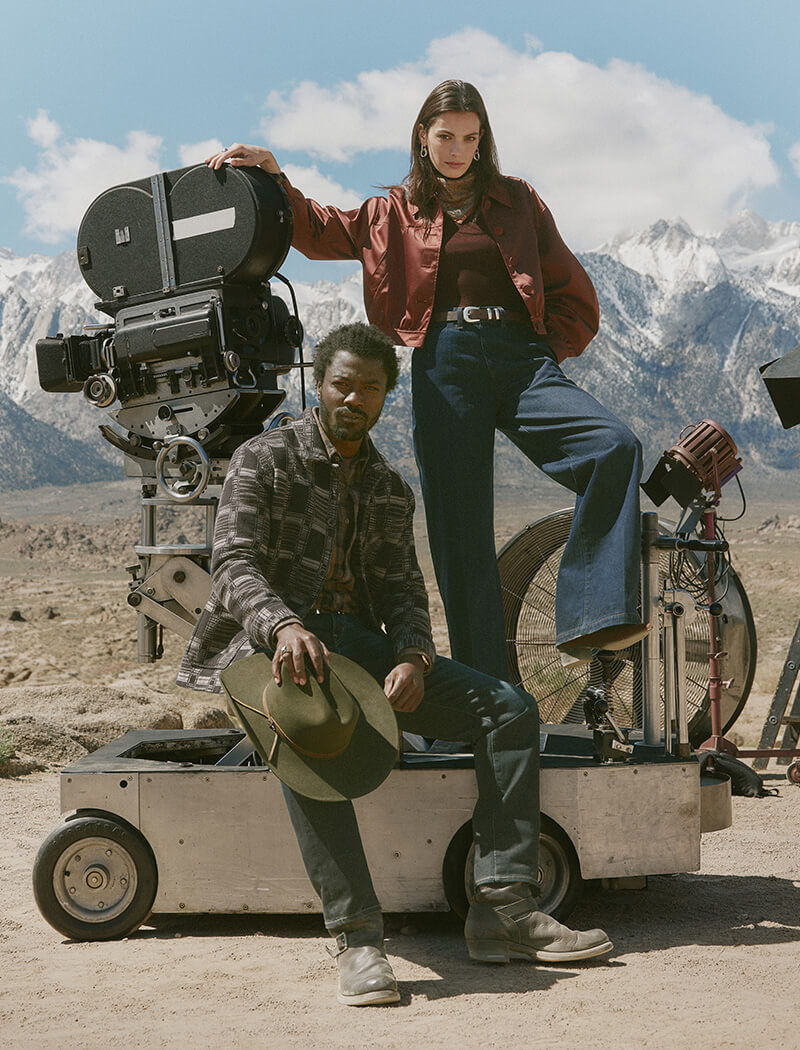 Two people on a film set with mountains in the background