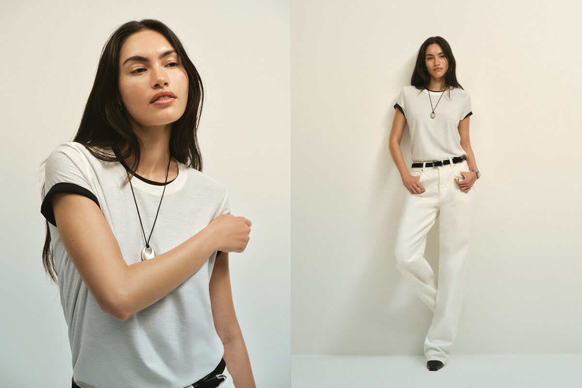 Woman wearing a white t-shirt and pants against a plain background